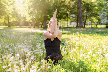 Sporty woman doing yoga exercises in different places (in a park in summer)
