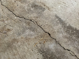 Close up photo of a crack in a concrete foundation. Structural repair and construction.