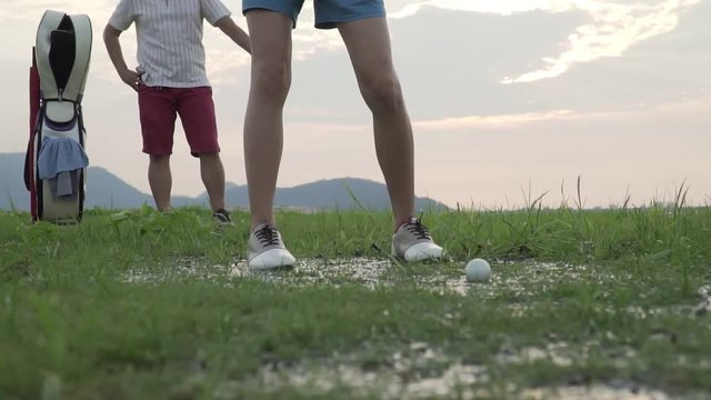 Footage B Roll Of Slow Motion Couple Lover In Action Of Playing Golf Together. Golf Ball Away From The Rough To Fairway, Difficult Time Stay Together In The Family Course. Beautiful Nature Silhouette.