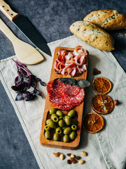 minimize with three cells with olives sausage and bacon decorated with dried fruits and Basil