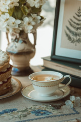 Vintage cup with tea and flowers