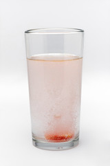 soluble effervescent multivitamin in a glass glass with water on a white background
