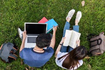 Top view university campus young students college sitting on grass with the man use laptop and woman read thai book consult learning together