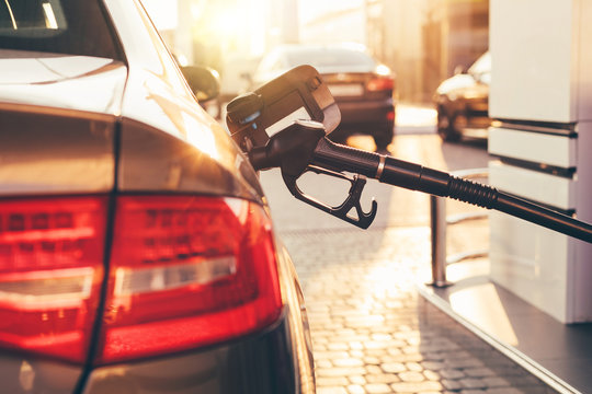Petrol pump filling nozzles in tank at gas station. Selective focus. Close-up