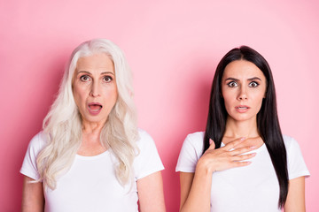 Photo of attractive old mother young daughter two ladies bad mood listen unexpected awful sad news wear casual white t-shirts isolated pastel pink color background