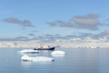 Expedition ship with iceberg in Antarctic sea at anchor  