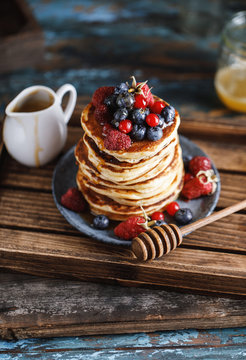 Pancakes with berries and maple syrup. Sweet homemade stack of pancakes