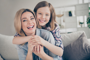 Closeup photo of domestic attractive blond lady mommy daughter sitting comfy couch hugging...
