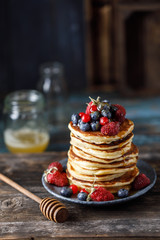 Pancakes with berries and maple syrup. Sweet homemade stack of pancakes