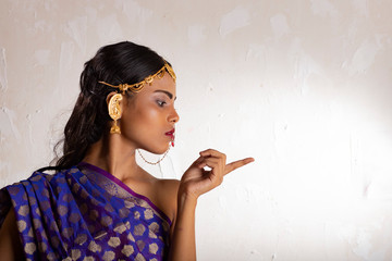 Indian girl wearing a traditional blue saree and gold jewellry