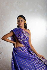 Indian girl wearing a traditional blue saree and gold jewellry