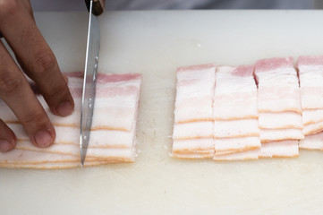 Slicing bacon with a knife