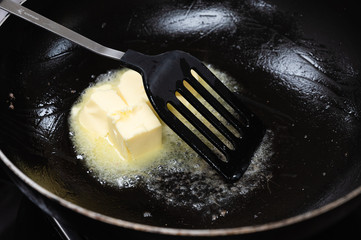 Butter is melting in a black pan
