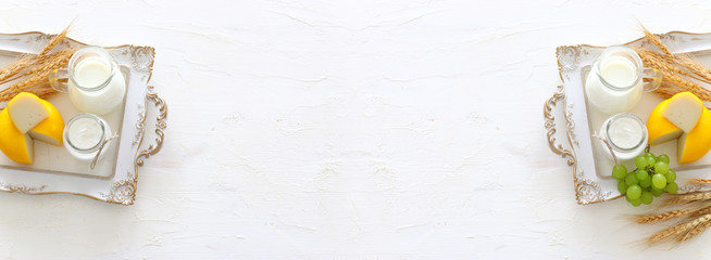 Top view photo of dairy products over white background. Symbols of jewish holiday - Shavuot