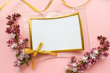 lilac branch and photo frame on a pink background