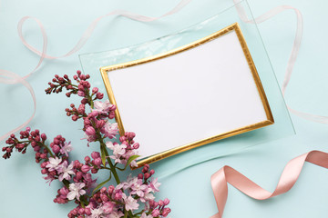 lilac branch and photo frame on a blue background