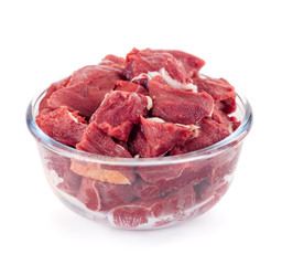 Pieces of fresh beef in a glass bowl isolated on white background