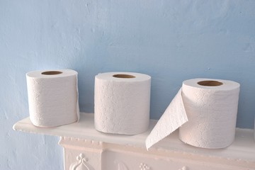 Toilet paper rolls on blue background.