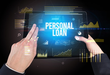 Close-up of hands holding tablet with PERSONAL LOAN inscription, modern business concept