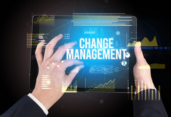 Close-up of hands holding tablet with CHANGE MANAGEMENT inscription, modern business concept