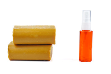 Sanitizer bottle and two bricks of brown common soap isolated on a white background