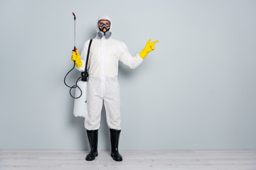 Stay home. Photo of specialist disinfectant guy clean public places pandemic spray chemicals show colleague his territory wear hazmat protective suit isolated grey color background