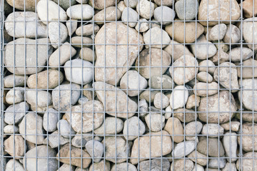 Background of a stone wall of gravel behind bars.