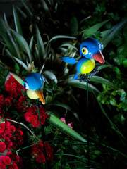 Uccellini colorati finti su fiori