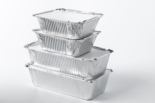 Takeaway meal in foil food box on white background close up