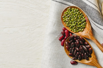 dried beans in wooden spoons on the table, close up