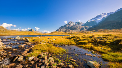 Sun is setting at Lej Pitschen, together with Lej Nair and Lago Bianco one of three lakes at The Bernina Pass. It connects Swiss Engadin valley with Val Poschiavo and ends in the Italian town Tirano