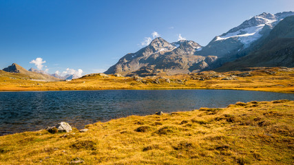 Sun is setting at Lej Pitschen, together with Lej Nair and Lago Bianco one of three lakes at The Bernina Pass. It connects Swiss Engadin valley with Val Poschiavo and ends in the Italian town Tirano