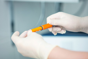 Doctor's hands in gloves with a syringe with an injection or a vaccine close up