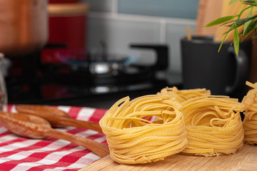 Dry spaghetti on a kitchen counter with cooking utensils close up