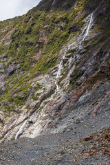 Stones and small waterfall. Franz Joseph Glacier. South Island, New Zealand