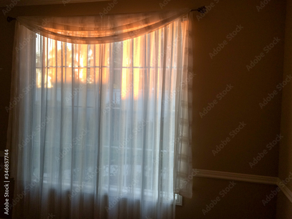 Wall mural gold sunlight streams through curtains for golden design background on room wall