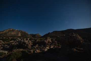 Night mountains view with star sky and full moon of the The petrified forest park in Lakonia,...