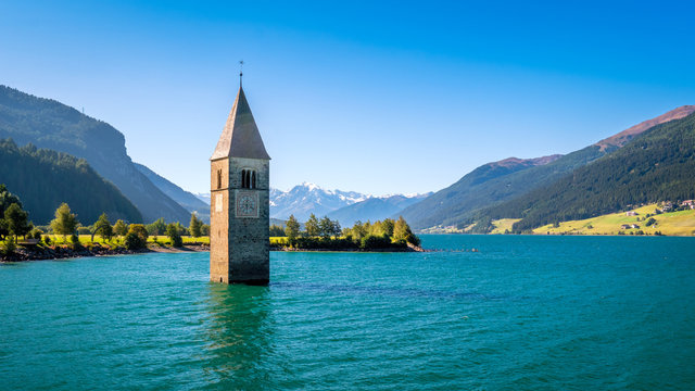 Lake Resia (Reschensee) and Ortler Mountains in Val Venosta (Alto Adige, Italy). It is famous for the tower of a 14th-century church of village Graun that submerged when the lake was deepened in 1950