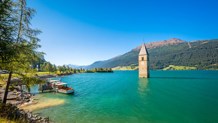 Lake Resia (Reschensee) and Ortler Mountains in Val Venosta (Alto Adige, Italy). It is famous for the tower of a 14th-century church of village Graun that submerged when the lake was deepened in 1950