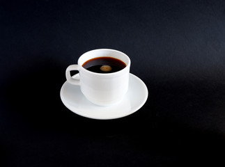 Obraz na płótnie Canvas A Cup of black coffee on a black background. Suitable for layouts and advertising backgrounds