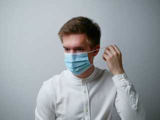 Man wearing a blue protective face mask against coronavirus. Medical staff preventive gear. White background.
