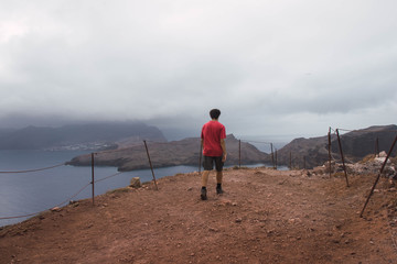 Hiker in the mountains with the sea in the background. Cloudy sky in Ponta de S&atilde;o Louren&ccedil;o, Madeira. 