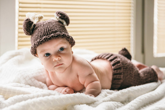 Three month old baby in a knitted deer costume for newborn photography. Lovely first months of life