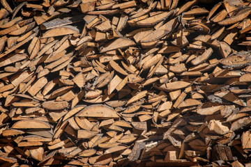 A pile of firewood, firewood wall of an old wooden house, preparation of firewood for the winter.
