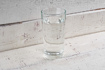 Glass water close up on grunge wooden background