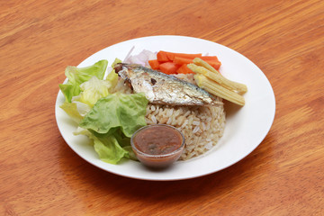 Breakfast in the white round plate. Fried mackerel and Rice with Spicy Shrimp Paste Dip and vegetable, Chinese cabbage, baby corn, carrots and sliced onions.