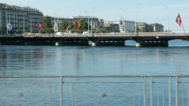Mont-Blanc bridge with flags of red crescent, Switzerland, Geneva and red cross floating over Leman lake