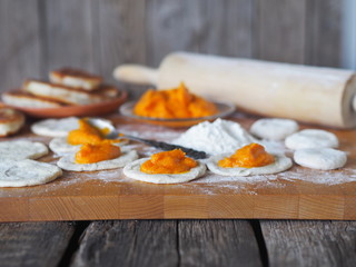 Culinary dietary background.The process of cooking homemade pies with pumpkin.