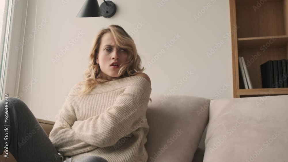 Poster Displeased angry blonde woman indoors at home using mobile phone