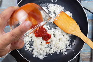 Chef pouring ketchup to pan for cook fried rice
